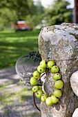 Wreath made of wild apples on an old mossy gatepost