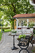 Terrassenplatz mit Gartenbank und rundem Tisch