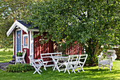 Seating group under apple tree next to small tool shed