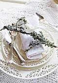 White Christmas place setting, decorative bird perched on a branch covered with lichen