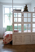 Room dividers made of old windows and a coffered door in a bedroom