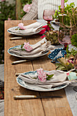 Linen napkins decorated with roses on set table in garden