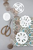 Decorations cut out of paper, garland of capiz shells and pair of scissors