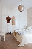 Double bed and white built-in wardrobe in the bedroom in beige tones