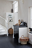Kitchen counter with ethnic accessories next to foot of staircase in open-plan interior