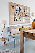 Pinboard made from wooden planks above grey bench and rustic dining table