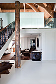 Baumstamm mit Rinde als Balken im modern offenen Wohnzimmer