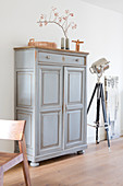 Old gray cupboard with wainscotting doors with simple decorations