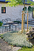Seating group and plant bed in front of old farmhouse