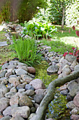 Bachlauf mit Steinbegrenzung im Garten