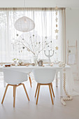 White shell chairs around festively decorated dining table