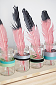 color dipped Pink feathers in screw jars with washi tape