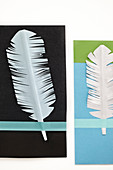 Homemade feathers from white paper on cards