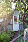 Picturesque summerhouse in flowering summer garden