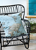 Homemade pillow with map motif on a black rattan chair