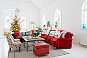 Living room with red couch and armchairs in a restored mission style house