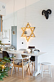 Dining table in an open kitchen that is decorated for Christmas
