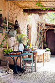 Tisch mit Bananenstaude und Pinienzapfen auf mediterraner Terrasse