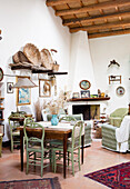 Small dining area and comfortable armchairs in front of a fireplace in a Mediterranean room