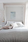 A grey knitted blanket on a double bed