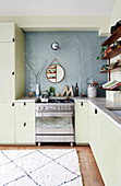 Einbauküche über Eck und blaue Wandfliesen in offener Küche