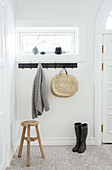 Wooden stool, coat rack, and boots in the hall