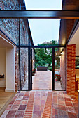 View onto patio area from extension, featuring a glass ceiling between the old farmhouse and contemporary extension