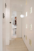 White hallway with glass blocks, bathroom door open in the background
