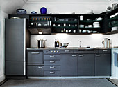 An anthracite-coloured kitchen with black open shelves above it