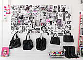Schwarze Handtaschen hängen an der Wand mit Collage in Schwarz-weiß