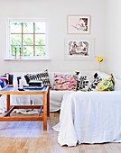 Colourful cushions and a white throw on a sofa in a living room