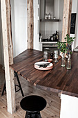 An elegant wooden work surface as a breakfast bar, integrated into wooden supports
