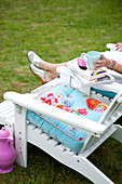 White deck chair with colorful pillows in the garden