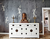 White Chinese sideboard with Buddha figure and candle holders