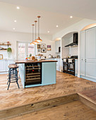 Herringbone parquet floor and island counter in open-plan kitchen in country-house style