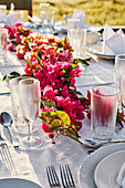 Set table outdoors decorated with garland of bougainvillea flowers