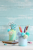 Pen holders handmade from tin cans and decorated with pompoms