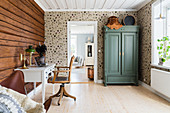 Study with log-cabin wall and wallpaper with botanical pattern