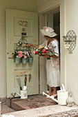 Organiser and utensils hung on inside of back door and woman holding basket of roses