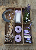 Lavender flowers, poppy seed heads and decorative materials in rustic divided tray