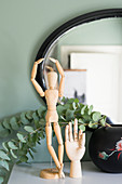 Artists' mannequin, model of hand and eucalyptus branches in front of mirror