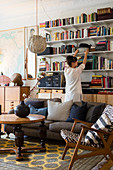 Woman in front of bookcase in eclectic, vintage-style living room
