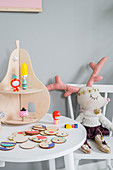 Pear-shaped shelves on child's table and reindeer soft toy