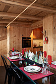 Festively set table and black chairs in dining area of chalet