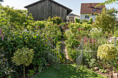 Open garden gate leading into cottage garden