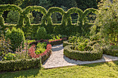 Knot garden with gravel path and artfully cut hedge