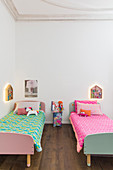 Colourful blankets on twin beds in siblings's bedroom in period apartment