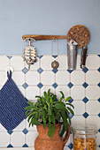 Perforated wooden spoon used as wall bracket for kitchen utensils