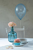 Balloon floating over table set in pale blue and pink