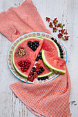 Watermelon slices with heart-shaped cut-outs filled with berries